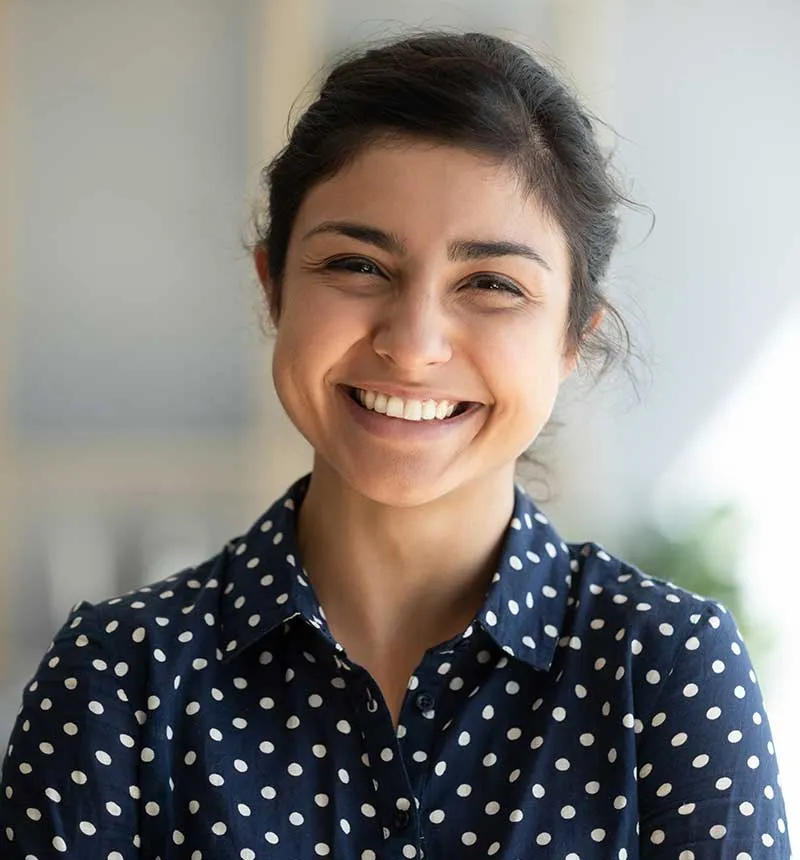 Smiling woman showing results of porcelain crown dental treatment in Phoenix
